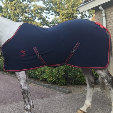 Breathable fleece horse rug with chest flap and adjustable cross surcingles fitted on horse, featuring navy fleece fabric and red binding.