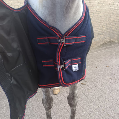 Double front closure system with male and female fastening on fleece horse rug, providing secure fit and easy adjustment.