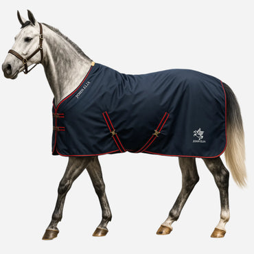 Horse wearing John Elia waterproof 1200D turnout rug in navy blue with red trim, lightweight 0g turnout rug for outdoor use.